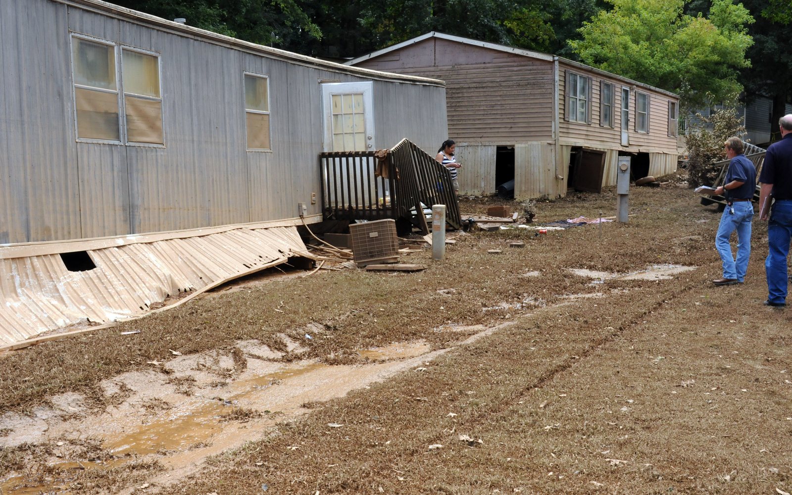 Flood-mudded mobile homes with inspectors on site
